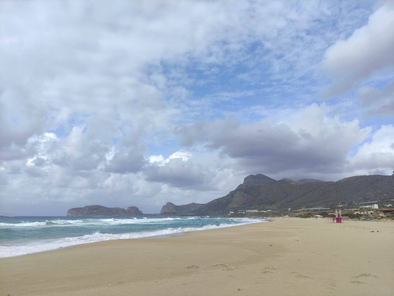 A wide view of the sandy beach and waves at Falasarna under a cloudy sky. — Falasarna-Riff (Platanos), Platanos, Region of Crete, Greece