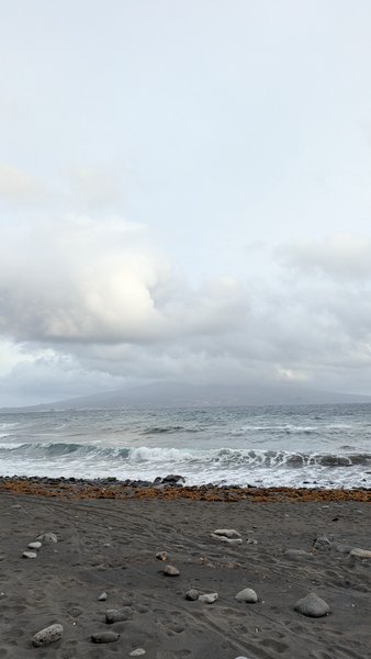 A view of the black sand beach and breaking waves at Praia do Almoxarife under an overcast sky. — Praia do Almoxarife (Almoxarife), Praia do Almoxarife, Portugal