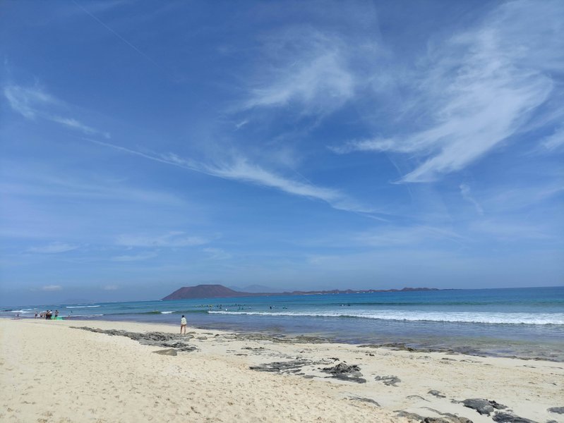 Wide view of the beach and surf at Los Hoteles with the island of Lobos in the distance. — Los Hoteles (La Oliva–Corralejo), La Oliva, Canary Islands, Spain