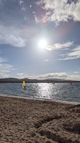 Windsurfers on the water at Isola Gabbiani under a bright sun. — Isola Gabbiani (Palau Coast), Lu Palau/Palau, Sardinia, Italy