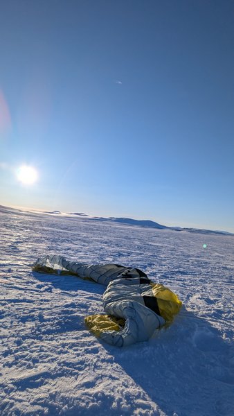 A snow kite rests on a vast, snowy plain under a clear blue sky at Dyratjornane. — Dyratjornane (Eidfjord), Norway