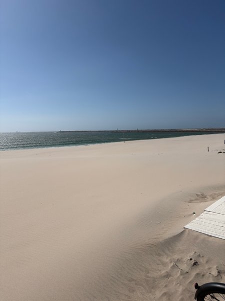 A wide sandy beach at Praia da Barra with the ocean and a breakwater in the distance. — Praia da Barra (Aveiro), Gafanha da Nazaré, Portugal