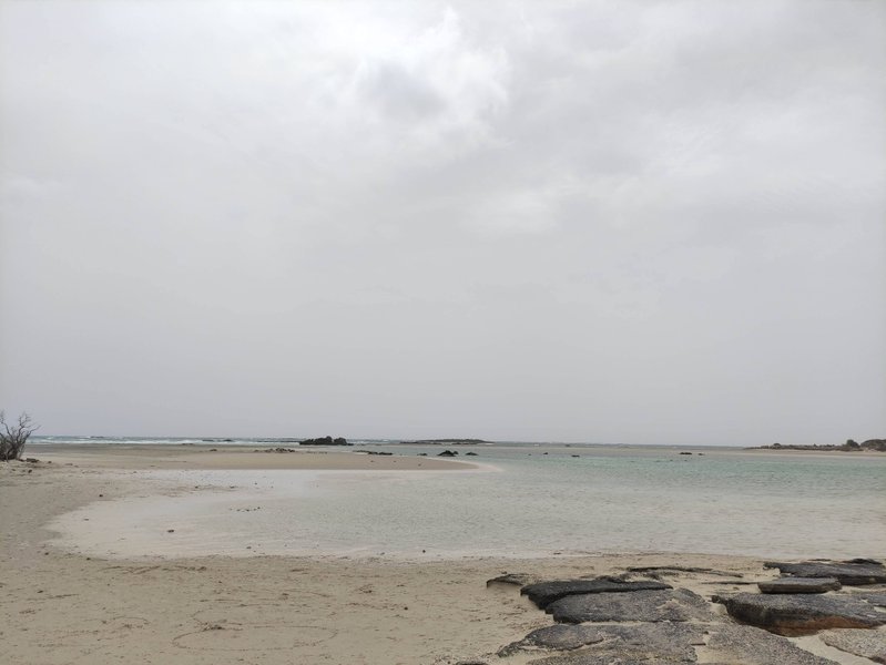 A wide view of the shallow lagoon and sandy beach at Elafonisi under an overcast sky. — Elafonisi-Strand (Kreta), Elafonisi Beach, Greece