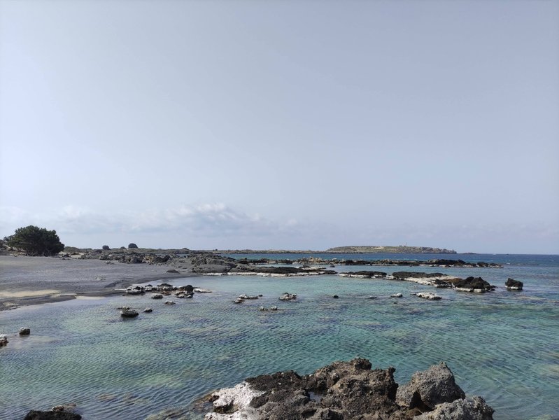 A clear view of the turquoise water and rocky coast at Elafonisi Beach. — Elafonisi-Strand (Kreta), Elafonisi Beach, Greece