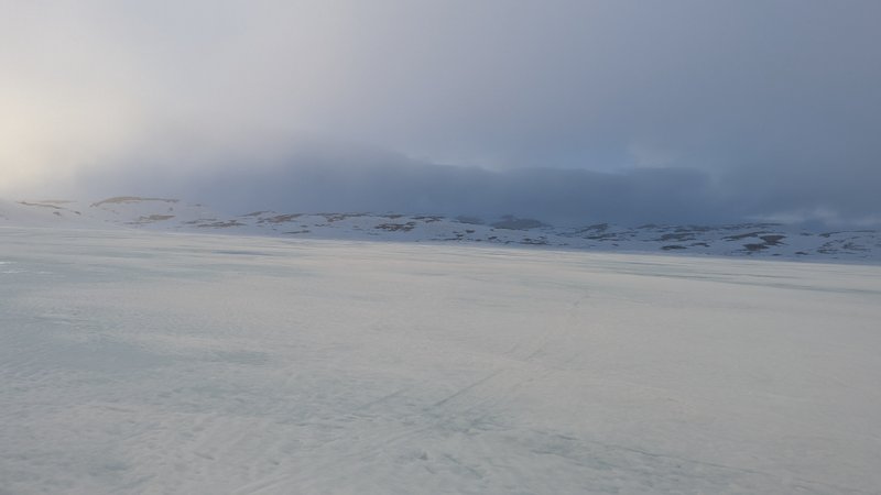 A wide, snow-covered landscape with distant hills under a cloudy sky. — Oerteren, Buskerud, Norway