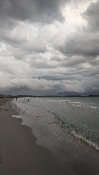 A view of the shoreline and water at La Cinta under heavy cloud cover. — La Cinta (San Teodoro), Santu Diadòru/San Teodoro, Sardinia, Italy