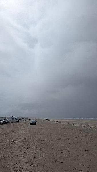 Vehicles parked on the wide sandy expanse of Inch Beach under a cloudy sky. — Inch Beach (Kerry), Ireland