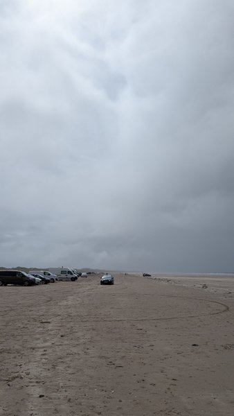 Cars parked on the sand at Inch Beach under a heavy overcast sky. — Inch Beach (Kerry), Ireland