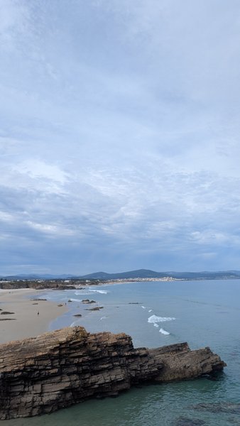 An aerial view of the rocky and sandy coastline of San Cosme with gentle waves breaking. — San Cosme (Foz), Suigrexa, Galicia, Spain